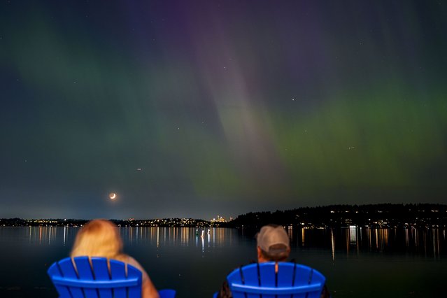 People view the northern lights, or aurora borealis, as they glow over Lake Washington, in Renton, Wash. (Photo by Lindsey Wasson/AP Photo)