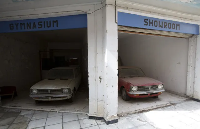 Cars sit abandoned in a former shopping centre in the United Nations buffer zone in central Nicosia March 12, 2014. The cars were imported from Japan to be sold at a Toyota dealership. They were stored here during the 1974 conflict and have not been moved since. (Photo by Neil Hall/Reuters)