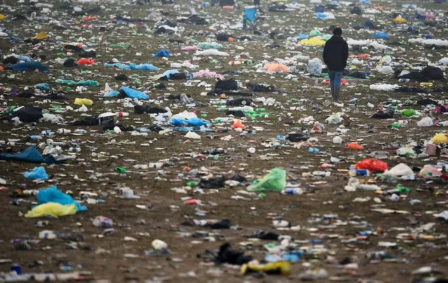 A reveller walks through rubbish left in front of the Pyramid Stage as they leave Worthy Farm in Somerset after the Glastonbury Festival in Britain, June 29, 2015. (Photo by Dylan Martinez/Reuters)