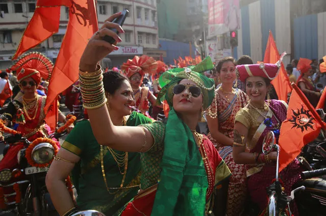 Women from India's western Maharashtra state dressed in traditional attire take selfies as they ride on motorcycles during a procession to celebrate “Gudi Padwa”, or the Marathi New Year, in Mumbai, India, Tuesday, March 28, 2017. (Photo by Rafiq Maqbool/AP Photo)