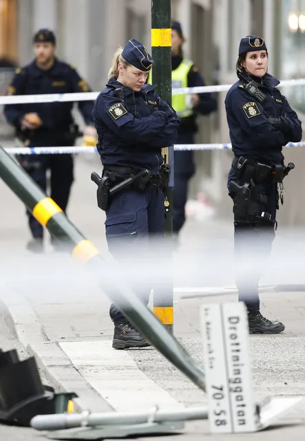 Police officers stand next to a destroyed street sign near the department store Ahlens following a suspected terror attack in central Stockholm, Sweden, Saturday, April 8, 2017. (Photo by Markus Schreiber/AP Photo)