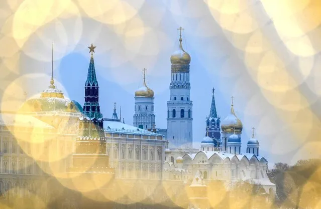 A picture taken in Moscow on February 1, 2022 shows Vodovzvodnaya tower (L) and Ivan the Great bell tower (R) in the Kremlin through illumination . (Photo by Natalia Kolesnikova/AFP Photo)