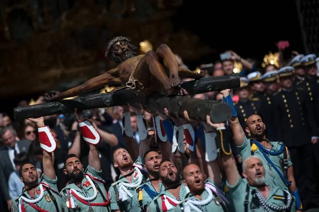 Members of the Spanish Legion carry a statue representing “El Cristo de la Buena Muerte” (The Christ of the Good Death), to Santo Domingo de Guzman Church during a Holy Week procession on April 13, 2017 in Malaga, southern Spain. Christian believers around the world mark the Holy Week of Easter in celebration of the crucifixion and resurrection of Jesus Christ. (Photo by Jorge Guerrero/AFP Photo)