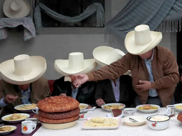 Peru's presidential candidate Pedro Castillo (R) hands over bread during a breakfast with members of his family before casting his vote, in Chugur, Peru on June 6, 2021. (Photo by Alessandro Cinque/Reuters)