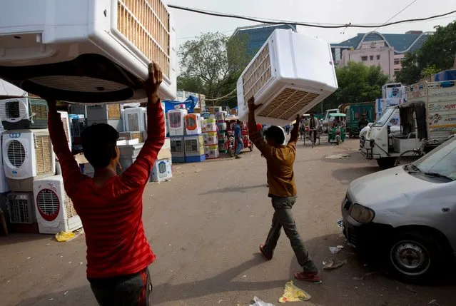 Indian workers carry assembled air coolers to a shop at a whole sale market as the demand for the same increases following sizzling temperatures in New Delhi, India, Tuesday, May 3, 2016. Much of India is reeling under a weeks long heat wave and severe drought conditions that have decimated crops, killed livestock and left at least 330 million Indians without enough water for their daily needs. (Photo by Manish Swarup/AP Photo)