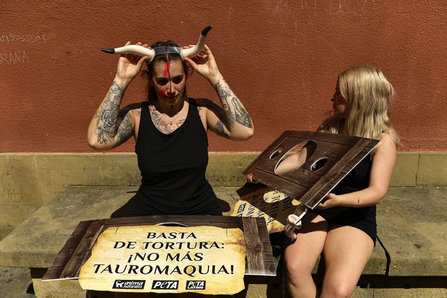 People prepare to take part in a protest against animal cruelty before the start of the San Fermin festival at Plaza del Ayuntamiento square as a banner reads, “Stop the torture; End Bullfighting”, in Pamplona, northern Spain, Friday, July 5, 2024. On July 6th, the San Fermin festival will begin and last for nine days where thousands of people will take part in the famous running of the bulls through the old streets of the city. (Photo by Alvaro Barrientos/AP Photo)