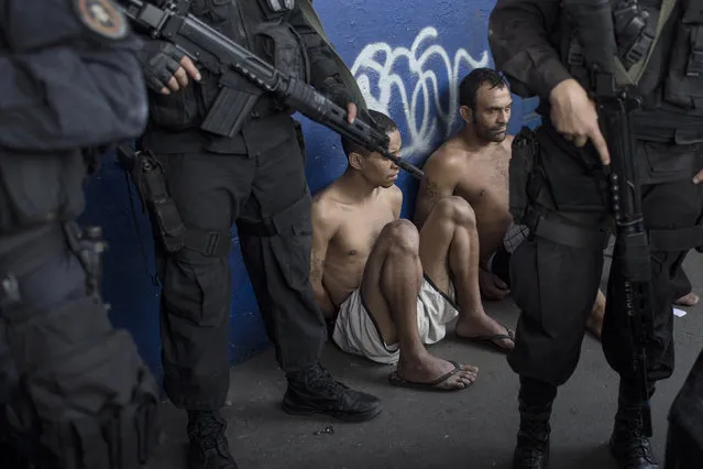 Suspects sit with their hands behind their backs after their arrest during a police operation in the Nova Holanda slum, part of the Complexo da Mare, in Rio de Janeiro, Tuesday, June 25, 2013. The police operation aimed to capture an alleged looter, who according to police killed an officer after a peaceful protest Monday night. At least seven people died and two suspects were captured during Tuesday's operation, according to police. (Photo by Felipe Dana/AP Photo)