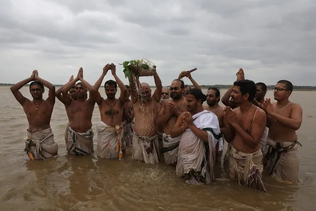 Hindu priests offer a prayer for monsoon rains at the Osman Sagar lake on the outskirts of Hyderabad, India, Thursday, July 9, 2015. The annual monsoon rains which usually hit India from June to September are crucial for farmers whose crops feed hundreds of millions of people. (Photo by Mahesh Kumar A./AP Photo)