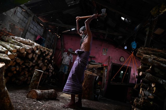 A worker cuts firewood at a workshop shop in Colombo on March 11, 2022. (Photo by Ishara S. Kodikara/AFP Photo)