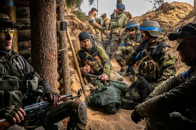 Ukrainian soldiers and foreign fighters wait before advancing in the streets during an operation to clear Russian forces from Irpin, Ukraine in March 2022. (Photo by Daniel Berehulak/New York Times/eyevine/Redux)