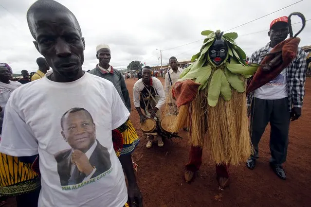 A supporter of Ivory Coast's President Alassane Ouattara wearing a t-shirt bearing his image, waits for his arrival as he makes his state visit at the Ouaninou village, in Touba, in northwestern Ivory Coast July 22, 2015. (Photo by Luc Gnago/Reuters)