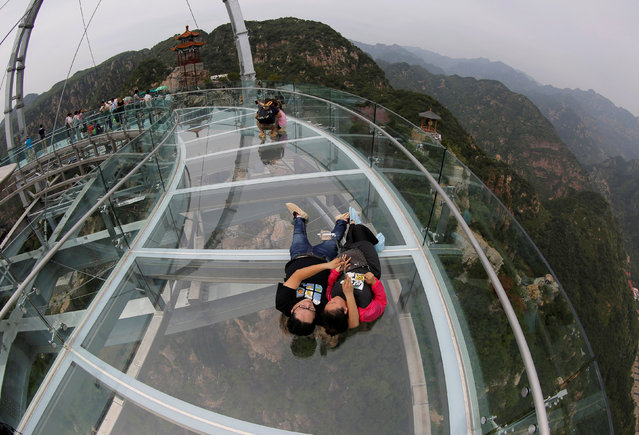 A couple takes a selfie on the glass sightseeing platform on Shilin Gorge in Beijing, China, May 27, 2016. (Photo by Kim Kyung-Hoon/Reuters)