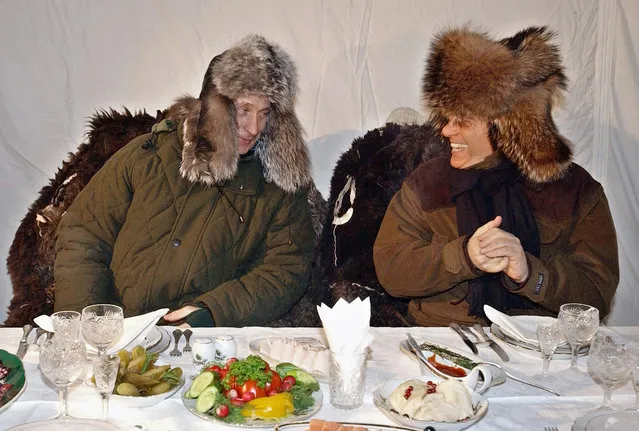 In this February 3, 2003 file photo Russian President Vladimir Putin, left, shares a word with former Italian Prime Minister Silvio Berlusconi during their informal outdoor dinner at the Zavidovo Putin's residence, about 120 km (75 miles) northwest of Moscow. A boast by Berlusconi that his old friend Putin had offered to make him economy minister made headlines around the world this week. (Photo by ITAR-TASS, Presidential Press Service via AP Photo)