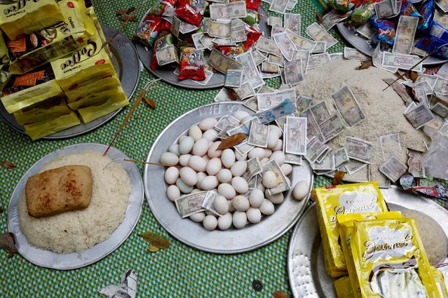 Money and food are prepared as an offering during a ritual at a Hau Dong ceremony at Lanh Giang temple in Ha Nam province, Vietnam, March 26, 2017. (Photo by Reuters/Kham)