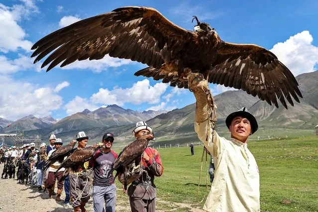 Kyrgyz berkutchi (eagle hunters) hold their birds, golden eagles, during the Solburun national hunt festival in the Kyrchyn gorge near Lake Issyk-Kul, 350 km from the country's capital of Bishkek, Kyrgyzstan, 30 August 2021. Salbuurun is a hunting game of the Kyrgyz people with hunting birds and dogs. In Kyrgyzstan, hunting with golden eagles is still a popular way to feed a family. (Photo by Igor Kovalenko/EPA/EFE)