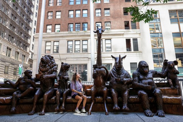 A person looks at a giraffe sculpture that is part of “The Wild Couch Party and Friends”, a public art sculpture exhibited in New York City that depicts some of the world’s most endangered animals as the planet experiences its 6th mass extinction, and aims to raise awareness about the human role in these events in New York City, New York, U.S., July 11, 2024. (Photo by Caitlin Ochs/Reuters)