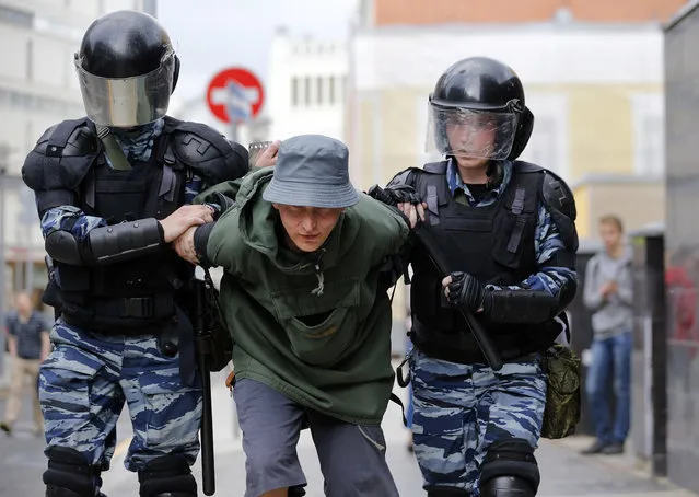 A man is led away after being detained during a demonstration in downtown Moscow, Russia, Monday, June 12, 2017.  (Photo by Alexander Zemlianichenko/AP Photo)