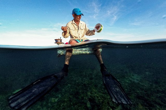 A Cuban fisherman prepares to fish in a makeshift raft in Havana Bay on July 16, 2024. When the weather permits, artisanal fishermen take to the water in improvised polystyrene rafts to make up for the lack of means and fuel. (Photo by Yamil Lage/AFP Photo)