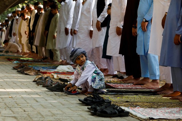 A boy plays as people attend Eid al-Fitr prayers to mark the end of the holy fasting month of Ramadan in Peshawar, Pakistan on May 2, 2022. (Photo by Fayaz Aziz/Reuters)