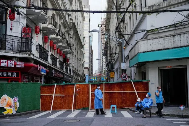 Workers in protective suits are pictured at a residential area during lockdown, amid the coronavirus disease (COVID-19) outbreak, in Shanghai, China, May 30, 2022. (Photo by Aly Song/Reuters)