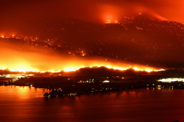 A long exposure image shows the Eagle Bluffs Wildfire, which crossed the border from the U.S. state of Washington, and prompted evacuation orders in Osoyoos, British Columbia, Canada on July 30, 2023. (Photo by Jesse Winter/Reuters)