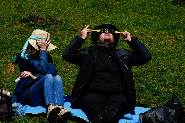 People watch an annular solar eclipse in Tahai, Rapa Nui, or Easter Island, Chile, Wednesday, October 2, 2024. (Photo by Esteban Felix/AP Photo)