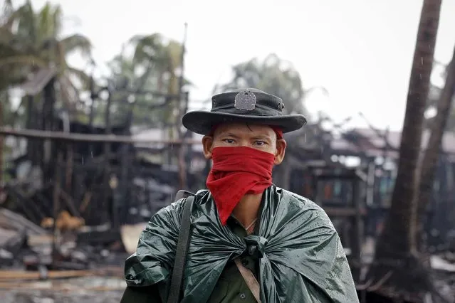 A soldiers patrols through a neighborhood burned in recent violence in Sittwe June 15, 2012