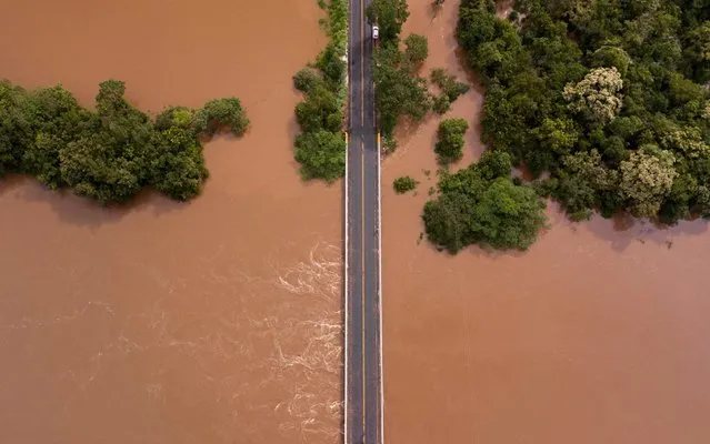 View of a bridge almost consumed by flood water on the border of the municipalities of Diamantina and Olhos D’Agua in Minas Gerais state, Brazil, on January 28, 2020. The levels of the Jequitinhonha River have risen to alarming levels following severe flooding in the state, which has already claimed close to 50 confirmed deaths and almost 19,000 people have been forced from their homes due to flood or landslide damage. (Photo by Nilmar Lage/AFP Photo)