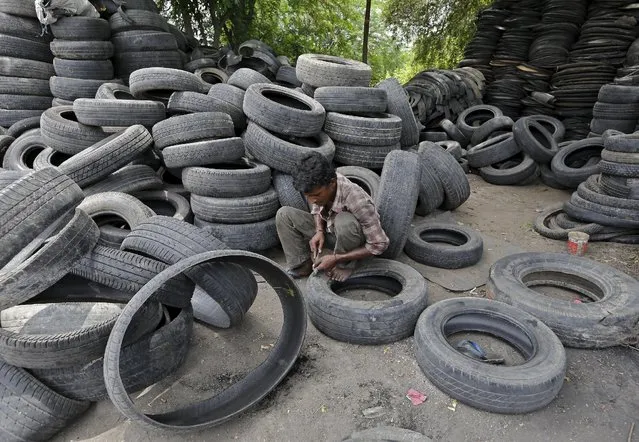 A man works at a tyre recycling unit on the outskirts of Ahmedabad, India, August 11, 2015. India's natural rubber production is likely to sink as much as 15 percent to its lowest in nearly two decades as farmers suspend tapping due to falling prices, rubber and tyre industry officials said. (Photo by Amit Dave/Reuters)