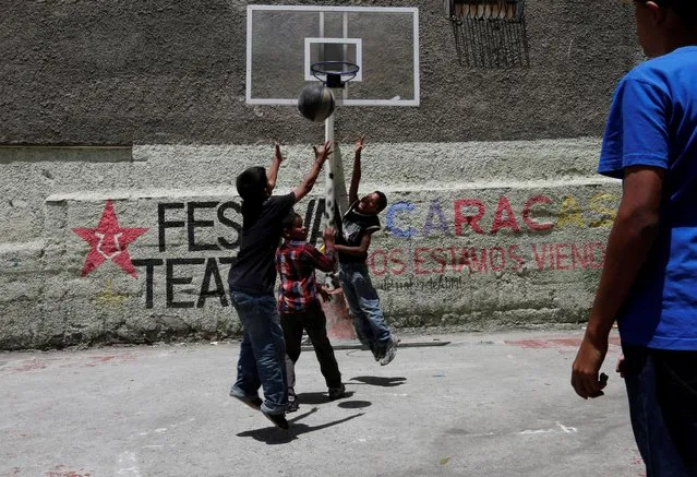 Kids play basketball on the street in Caracas, Venezuela, July 3, 2016. (Photo by Carlos Jasso/Reuters)