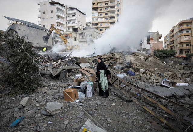 A woman looks for her belongings as she stands amidst the debris of a destroyed building, after a ceasefire between Israel and Hezbollah took effect, in Tyre, Lebanon on November 27, 2024. (Photo by Adnan Abidi/Reuters)