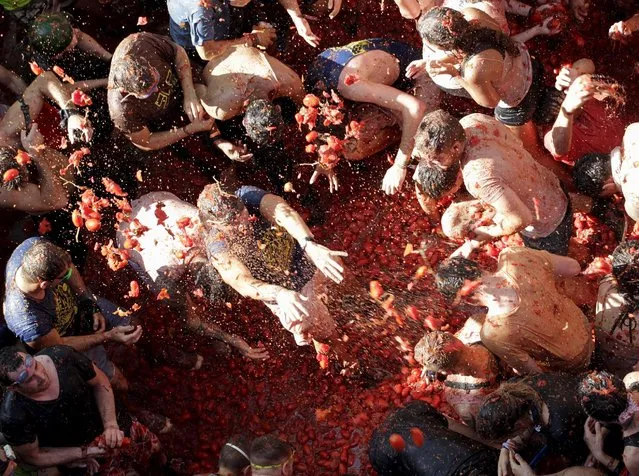 Revelers battle with tomatoes during the annual “Tomatina” (tomato fight) in Bunol, near Valencia, Spain, August 26, 2015. (Photo by Heino Kalis/Reuters)