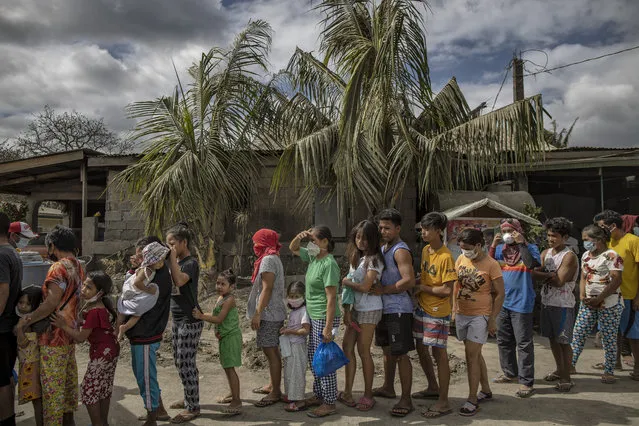 Residents queue up to receive relief goods on January 19, 2020 in the village of San Guillermo, Talisay, Batangas province, Philippines. The Philippine Institute of of Volcanology and Seismology has maintained the alert level four out of five, warning that a hazardous eruption could take place anytime, as authorities have evacuated at least 50,000 people from areas surrounding the volcano. An estimated $60 million worth of crops and livestock have been damaged by the on-going eruption, according to the country's agriculture department. (Photo by Ezra Acayan/Getty Images)