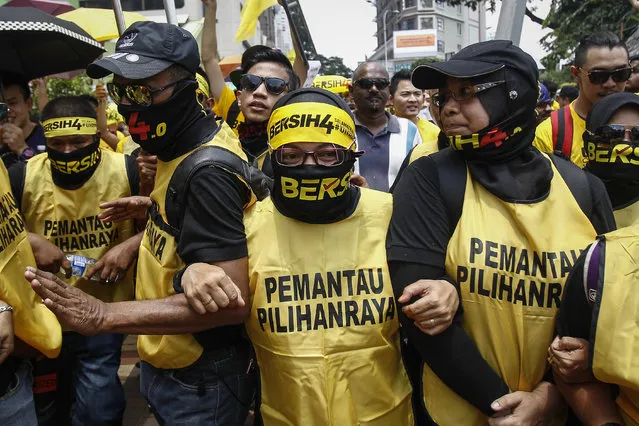 Activists from the Coalition for Clean and Fair Elections (BERSIH) marches during a rally in Kuala Lumpur, Malaysia on Saturday, August 29, 2015. Malaysian activists are putting more pressure on embattled Prime Minister Najib Razak to resign with major street rallies this weekend following allegations of suspicious money transfers into his accounts. (Photo by Joshua Paul/AP Photo)