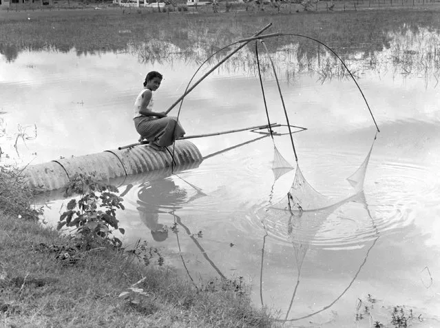 A woman fishing in a residential section of Vientiane, the capital and largest city of Laos, 1961. (Photo by Keystone Features)