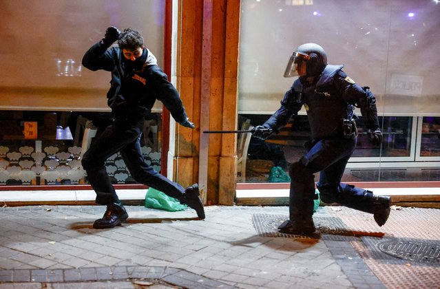 A Spanish riot police officer clashes with a demonstrator during a protest near Spain's Socialists Party (PSOE) headquarters, after Spain's socialists reached a deal with the Catalan separatist Junts party for government support, a pact which involves amnesties for people involved with Catalonia's failed 2017 independence bid, in Madrid, Spain on November 9, 2023. (Photo by Susana Vera/Reuters)