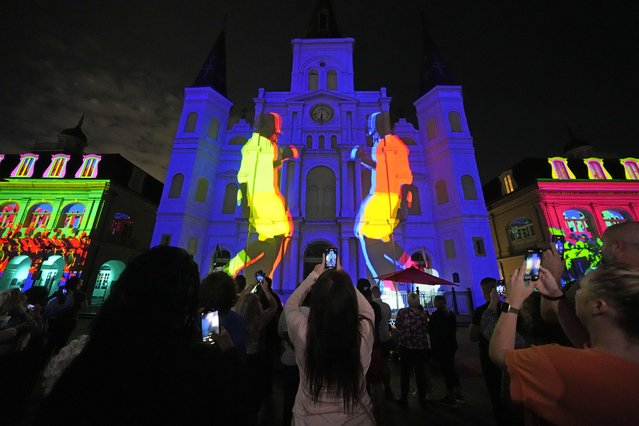 People watch a laser light show projected onto St. Louis Cathedral in the French Quarter, Tuesday, February 4, 2025, as part of the week's festivities leading up to Super Bowl 59 in New Orleans. (Photo by Gerald Herbert/AP Photo)