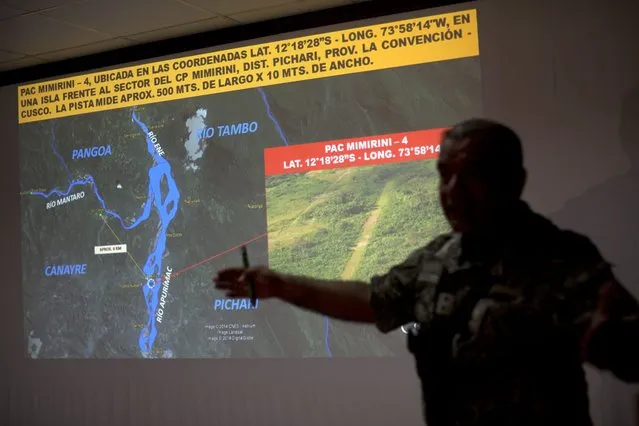 In this September 19, 2014 photo, a counternarcotics officer explains to the press the two weeks campaign to eradicate clandestine airstrips at the Mazamari counternarcotics military base in the Apurimac, Ene and Mantaro River Valleys, or VRAEM, the world's No. 1 coca-growing region, in Junin, Peru. The dynamiting of craters by Peruvian security forces into clandestine airstrips in the VRAEM cuts into profits but hardly discourages cocaine traffickers who net tens of thousands of dollars with each flight. (Photo by Rodrigo Abd/AP Photo)