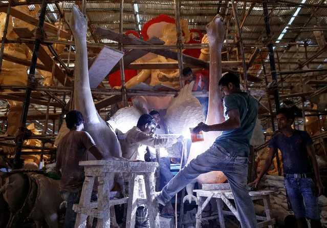 Artisans work on an idol of Hindu elephant god Ganesh, the deity of prosperity, at a workshop in Mumbai, India, August 8, 2016. (Photo by Danish Ismail/Reuters)