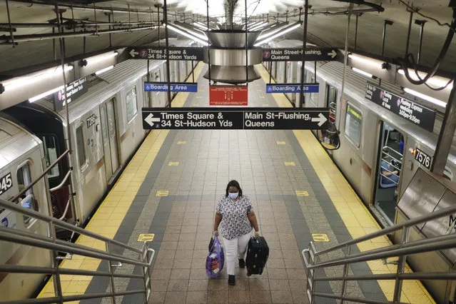 A commuters walks on a nearly empty subway platform in New York, Monday, June 8, 2020. After three months of a coronavirus crisis followed by protests and unrest, New York City is trying to turn a page when a limited range of industries reopen Monday. (Photo by Seth Wenig/AP Photo)