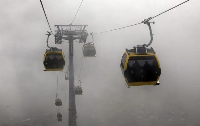 In this Thursday, September 18, 2014 photo, cable-cars move in the fog as people commute between the capital of La Paz with El Alto, Bolivia. The system is the world’s highest cable–car system, and transports thousands of passengers, about 4,000 meters above sea level. (Photo by Juan Karita/AP Photo)