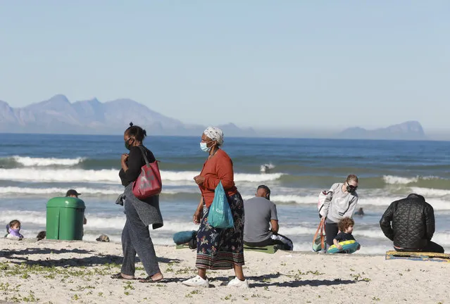 Women walk on the beach at Muizenberg, Cape Town, South Africa, Tuesday June 16, 2020. The country now has more than a quarter of the coronavirus cases on the 54-nation African continent with more than 73,000 cases after new, record-high infections were registered in South Africa over the weekend. (Photo by Nardus Engelbrecht/AP Photo)