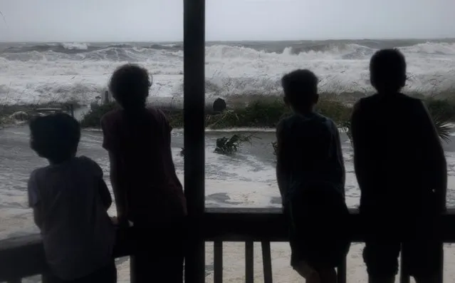 Kids watch as waves whip up from from the winds of Hurricane Ian in Myrtle Beach, SC on September 30, 2022. (Photo by Melissa Sue Gerrits for The Washington Post)