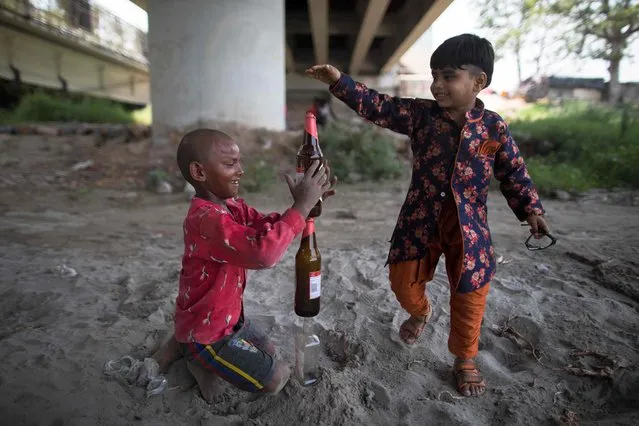 Children play under a bridge along the banks of the Yamuna river as temperatures rise in New Delhi on June 18, 2020. (Photo by Xavier Galiana/AFP Photo)