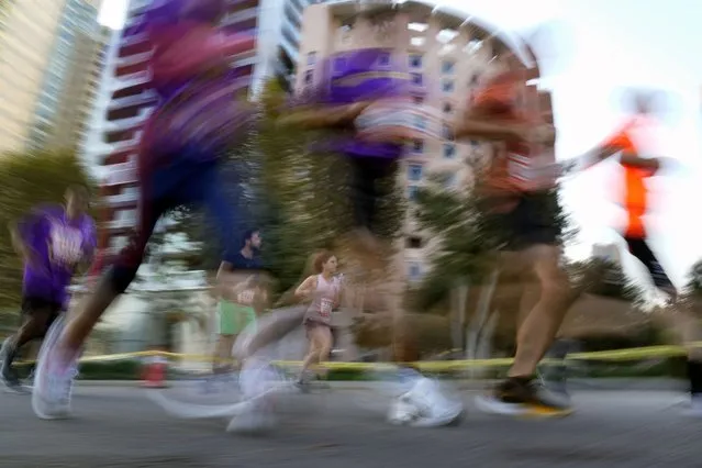 In this photo made with a slow shutter speed to show motion, runners compete in the 42-kilometer (26-mile) Beirut International Marathon in Beirut, Lebanon, Sunday, November 13, 2022. Thousands of runners from Lebanon and other nations participated in the 20th anniversary edition run. (Photo by Bilal Hussein/AP Photo)
