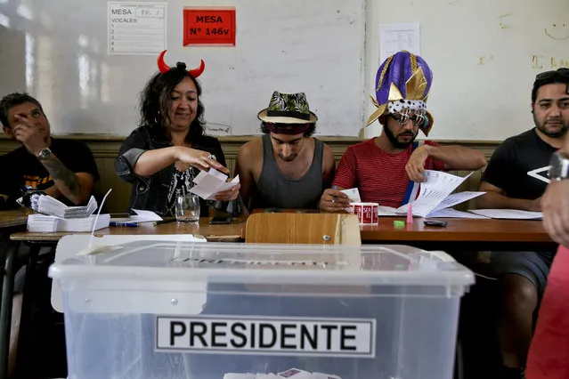 Electoral workers sport costumes during the presidential runoff election in Santiago, Chile, Sunday, December 17, 2017. Chileans will decide Sunday whether to swing the world's top copper-producing country to the right or maintain its center-left path in a fiercely contested election. (Photo by Esteban Felix/AP Photo)