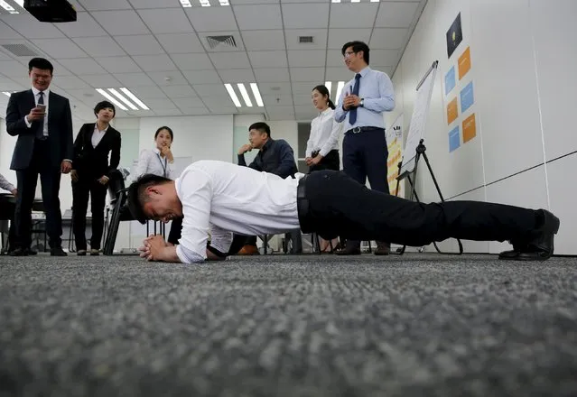 A dealership sales staff does a plank posture as part of the program during a sales camp at BMW Group Training Center in Beijing, China, September 9, 2015. (Photo by Kim Kyung-Hoon/Reuters)