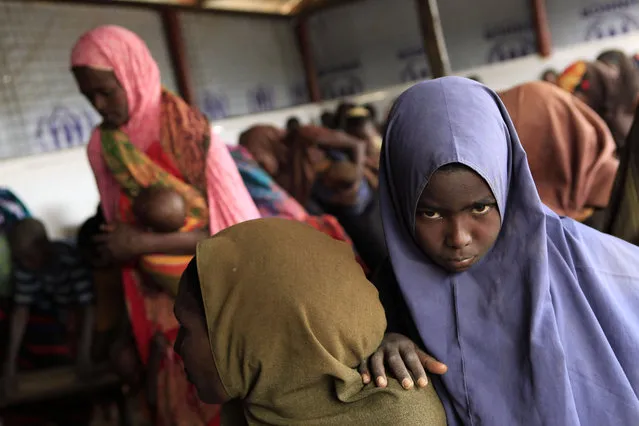 Recently-arrived Somali refugees wait to be registered at a reception center at Dagahaley Camp, outside Dadaab, Kenya, Sunday, July 10, 2011. (Photo by Rebecca Blackwell/AP Photo)