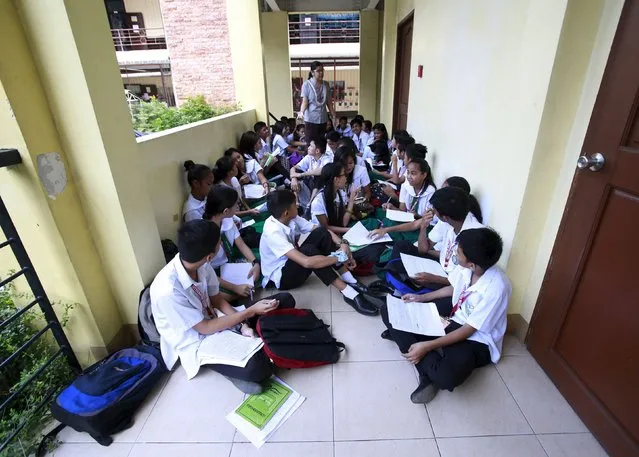 Teacher Kristine Passag holds a Values Education class for Grade 9 students in a hallway of Timoteo Paez High School in metro Manila, Philippines, September 15, 2015. Passag says she is temporarily holding classes in hallways while waiting for the completion of a new school building to address the shortage of classrooms. (Photo by Romeo Ranoco/Reuters)