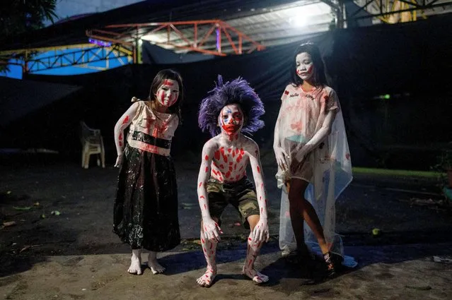 Children dressed for Halloween pose for a photo at a horror house in Manila, Philippines on October 31, 2022. (Photo by Lisa Marie David/Reuters)